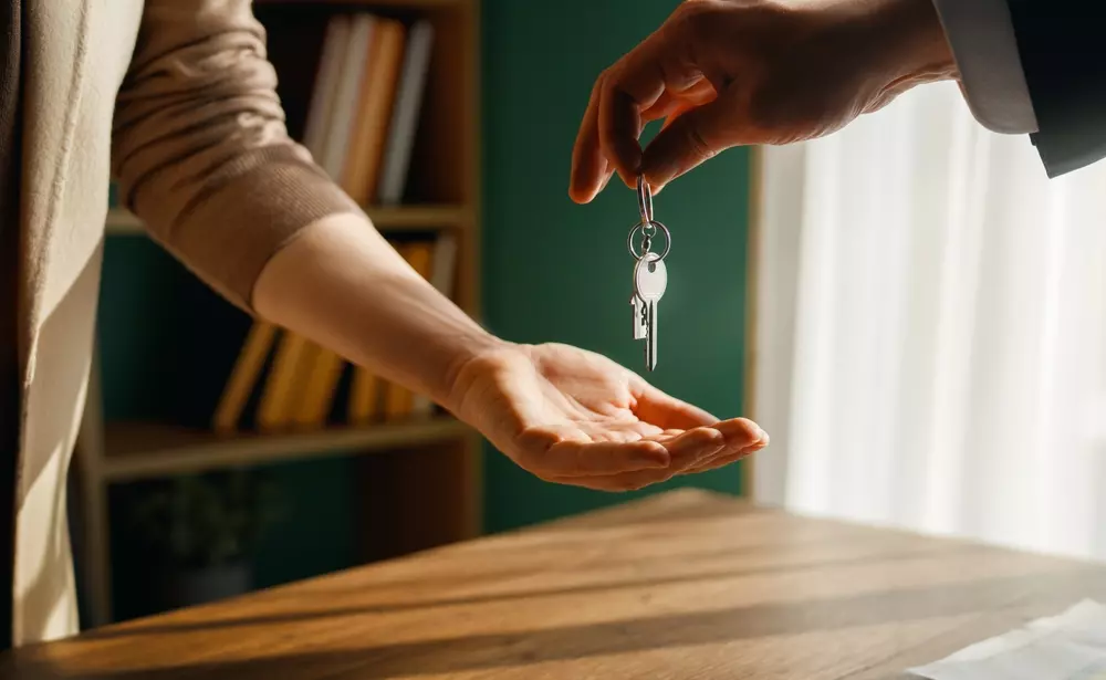 Pessoa recebendo as chaves de um imóvel após venda, simbolizando como usar o lucro da venda para alcançar novos objetivos financeiros. Ideal para negociações imobiliárias e investimentos.