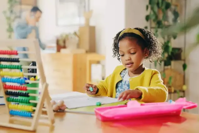 Foto trazendo o conceito de decoração educativa, com menina brincando com jogos educativos e brinquedos de matemática em sala de aula infantil moderna, promovendo desenvolvimento cognitivo e aprendizado divertido