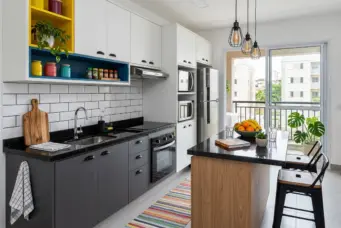 Uma cozinha moderna com ilha central, armários brancos e pretos, balcão de pia, eletrodomésticos embutidos, janelas grandes e decoração contemporânea.