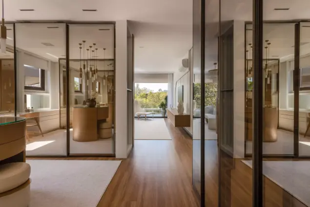 Espaço interno com vidro reflecta da Meneghisso & Pasquotto Arquitetura, refletindo iluminação natural e decoração moderna