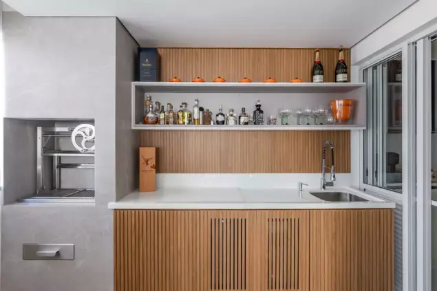 Projeto da arquiteta Cristiane Schiavoni mostrando um bar embutido em uma cozinha da área gourmet.