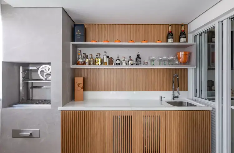 Projeto da arquiteta Cristiane Schiavoni mostrando um bar embutido em uma cozinha da área gourmet.